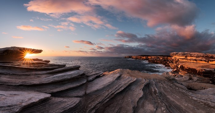 Sunset over the ocean with rock formations in Sydney, Australia