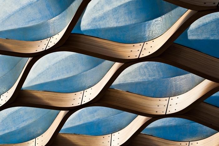 Abstract architectural pattern of curved wooden beams and blue panels