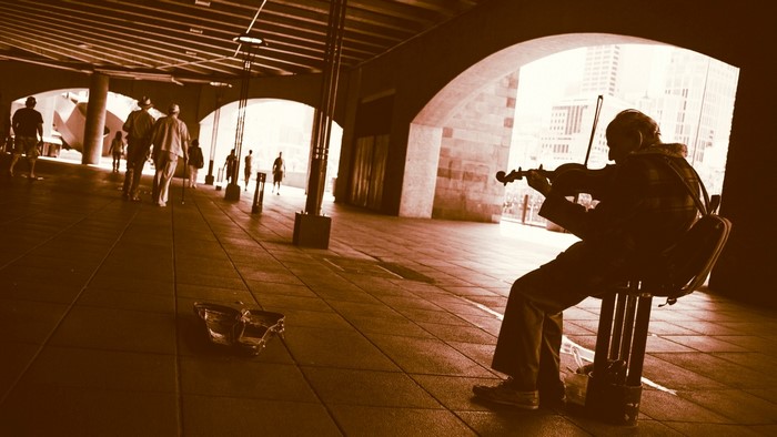 Street violinist playing under an archway