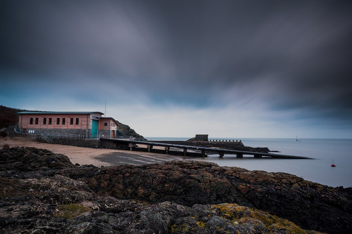Lifeboat station and pier on a rocky coast in Wales
