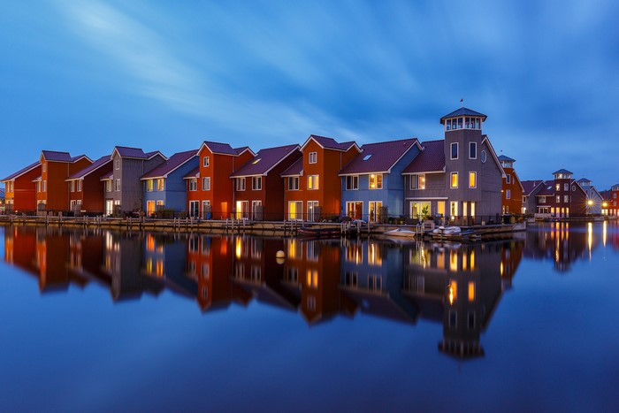 Colorful houses on water with reflections in Groningen, Netherlands