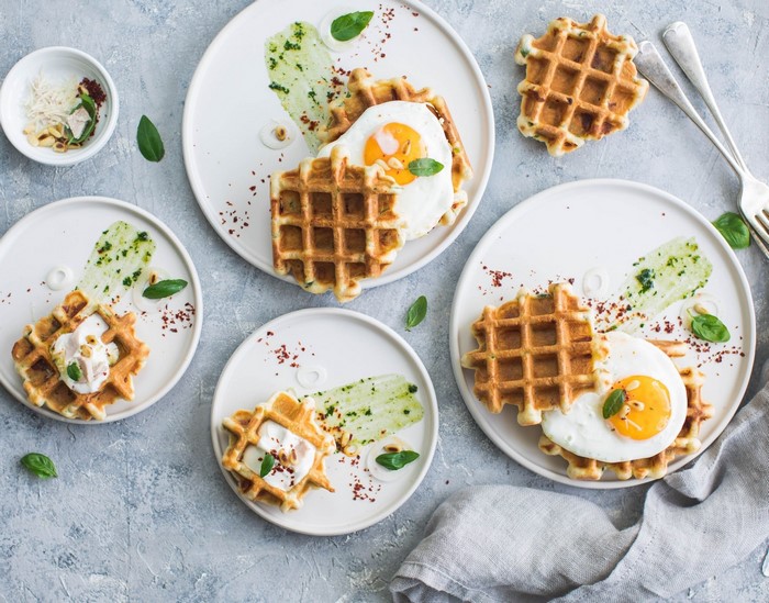 Waffles with fried eggs and green sauce