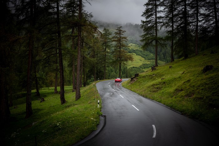 Red car on a wet mountain road in Switzerland