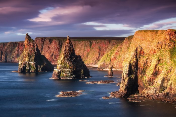 Dramatic sea stacks and cliffs at sunset in Scotland