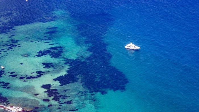 Aerial view of a yacht in the sea near a coast