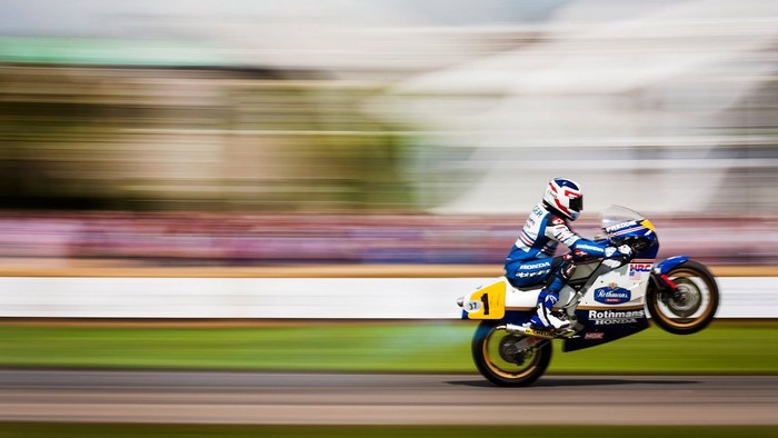 Motorcyclist performing a wheelie on a Honda motorcycle