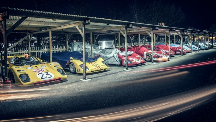 Race cars parked under a covered structure at night