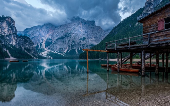 Wooden boathouse on a lake with mountains