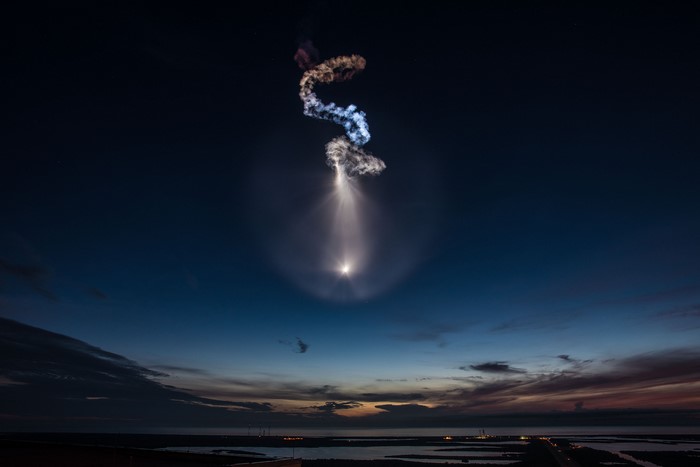 SpaceX rocket launch at night with colorful smoke trails