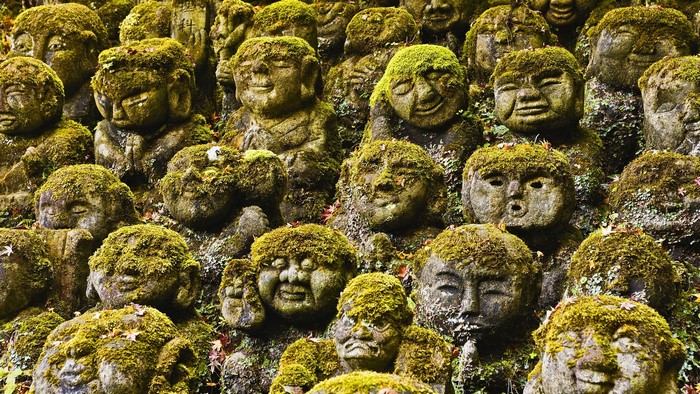 Stone Jizo statues covered in moss at a Japanese temple