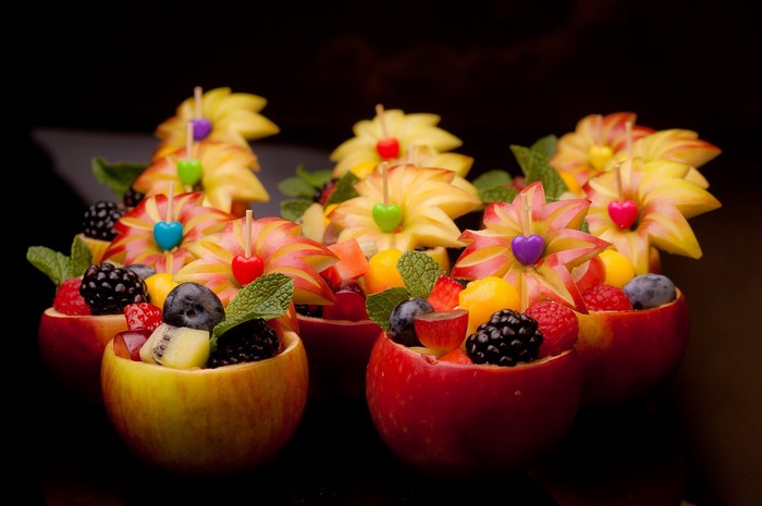 Fruit salad served in apple bowls with carved apple flowers