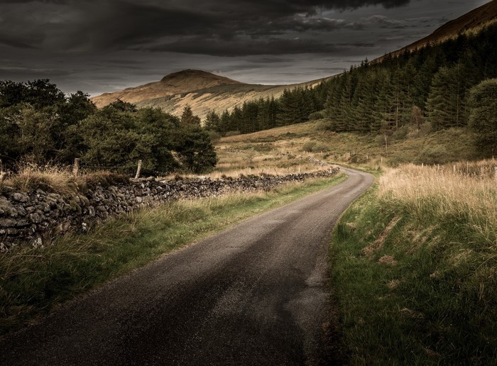 Winding road through a rural landscape with hills and trees