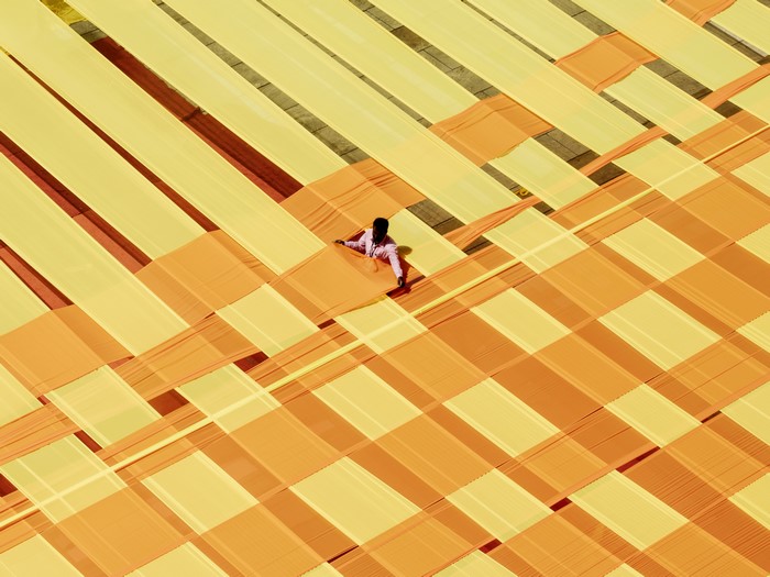 Person working with yellow and orange fabric