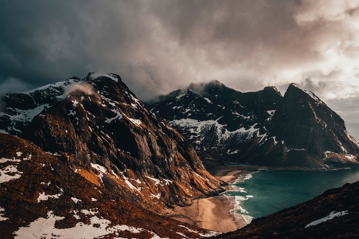 Snow-capped mountains overlooking a beach and ocean