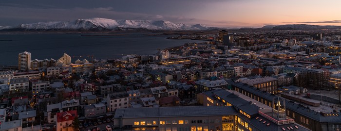 Reykjavik cityscape at sunset with snow-capped mountains