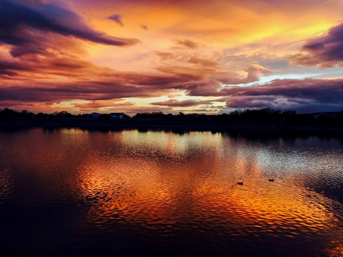 Sunset over a lake with colorful clouds and reflections