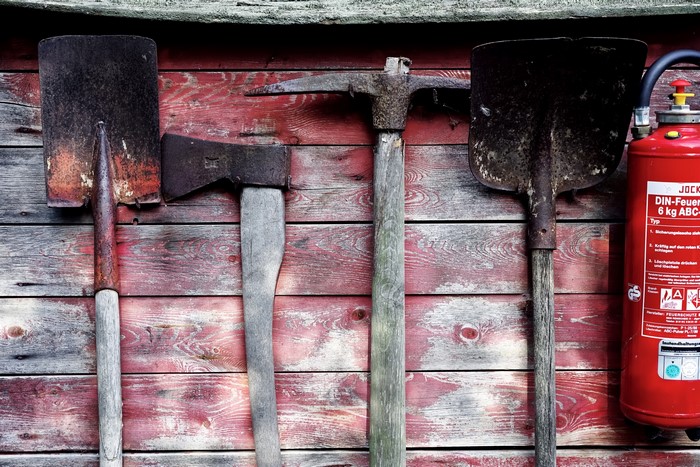 Tools and fire extinguisher on a wooden wall