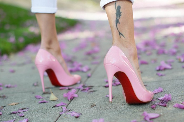 Woman wearing pink Louboutin high heels with mermaid tattoo