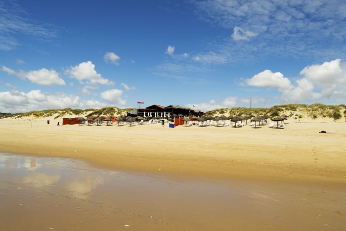 Beach with umbrellas and building in Portugal