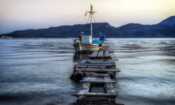 Boat docked at a weathered pier on the water