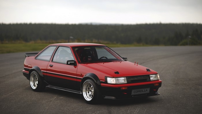 Red and black Toyota Corolla AE86 on asphalt