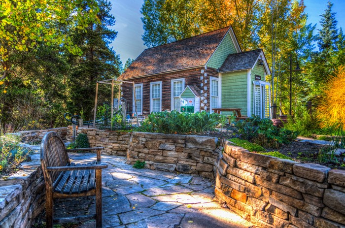Autumn garden with a small house and stone path