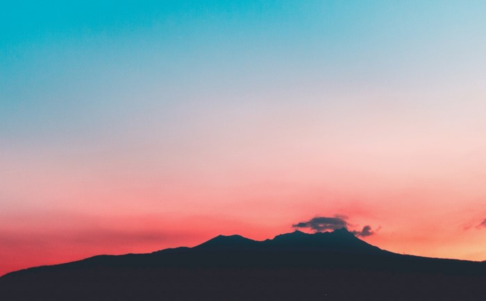 Silhouette of mountains against a colorful sunset sky