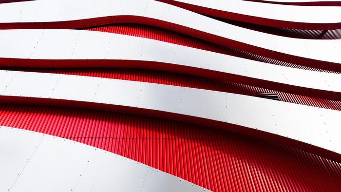 Abstract architecture with red and white wavy metal panels