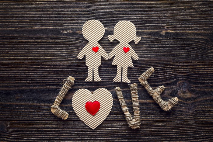 Cardboard cutouts of a couple and the word LOVE on wood
