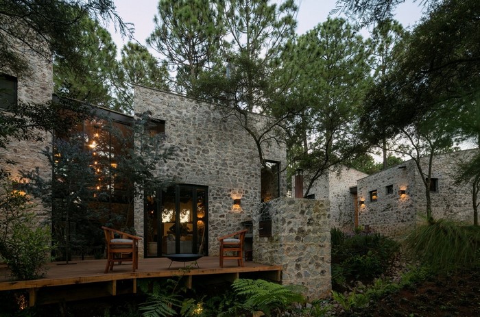 Stone building with large windows surrounded by trees