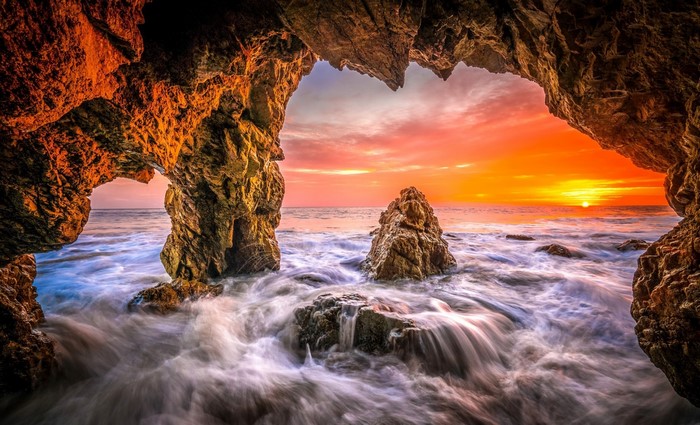Cave entrance overlooking ocean sunset