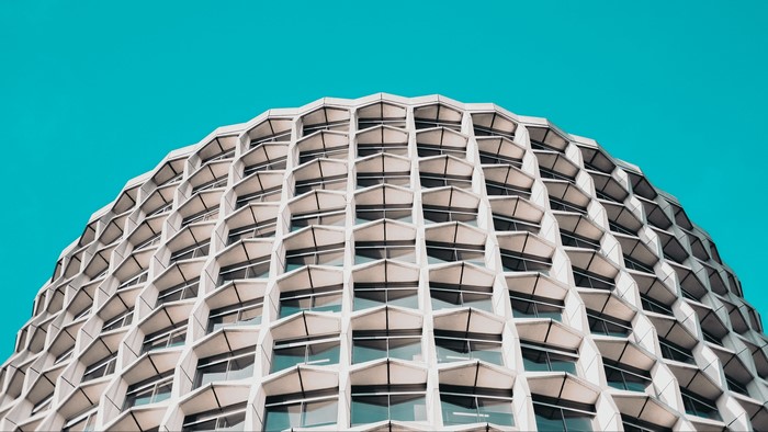 Modern honeycomb building against a cyan sky
