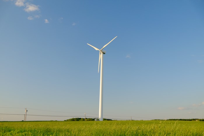 Windmill in a green field under a blue sky