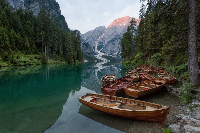 Boats on a lake with mountains and forest