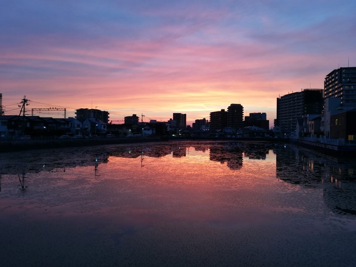 Sunset over a city skyline reflected in water