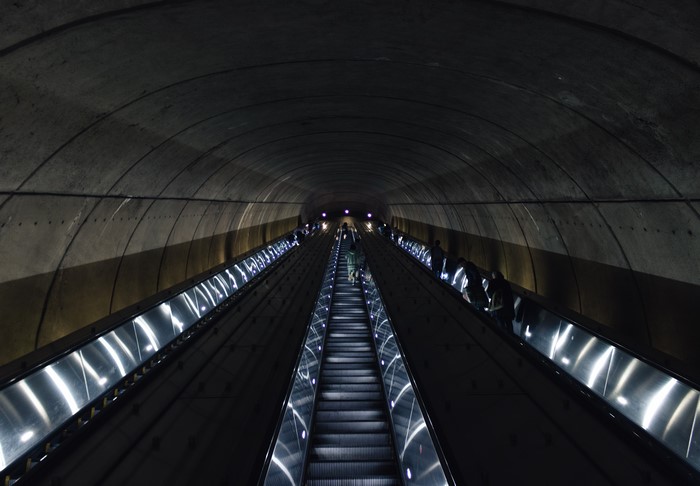People on escalators in a metro tunnel
