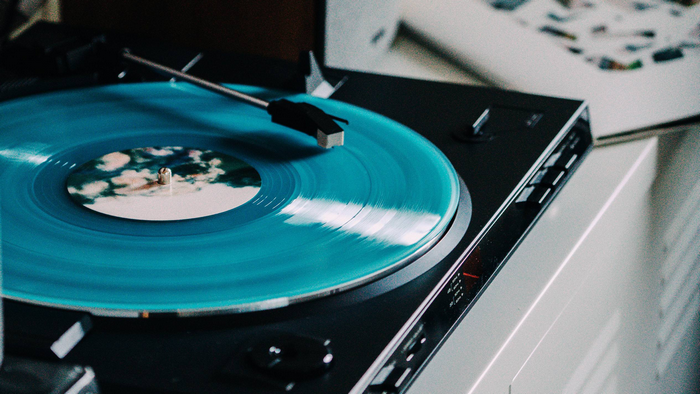 Turntable playing a cyan vinyl record