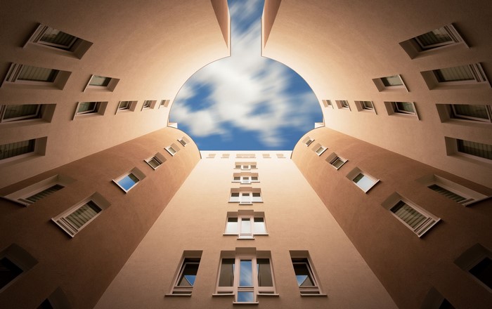 Looking up at a building courtyard with a sky view