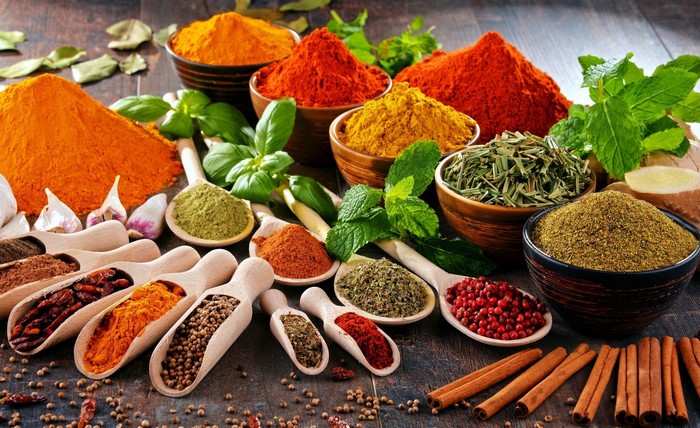 Assortment of colorful spices and herbs on a wooden table