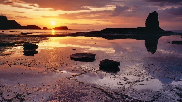 Sunset over rocky coast with tide pools