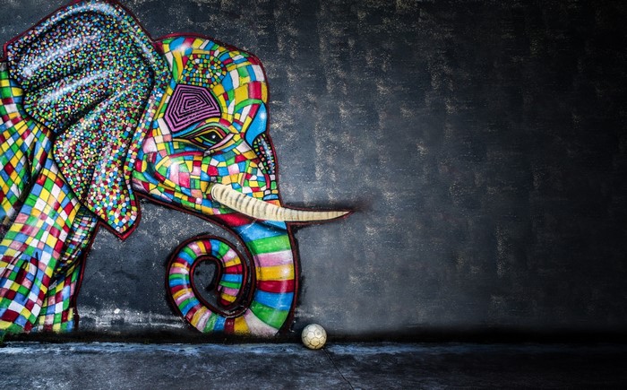 Colorful mosaic elephant artwork with a ball