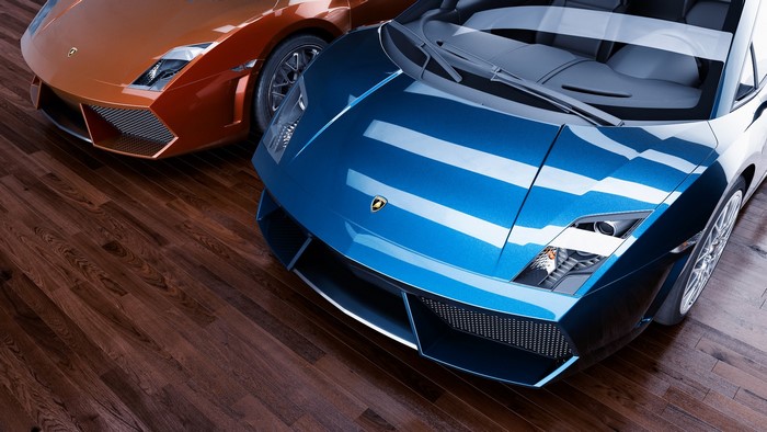 Two Lamborghini sports cars on a wooden floor