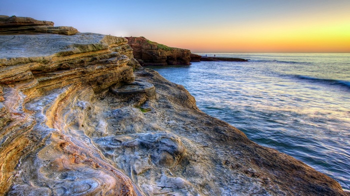 Rocky coastline at sunset with ocean waves