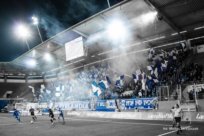 Football match with fans waving flags in stadium