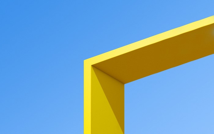 Yellow geometric structure against a clear blue sky