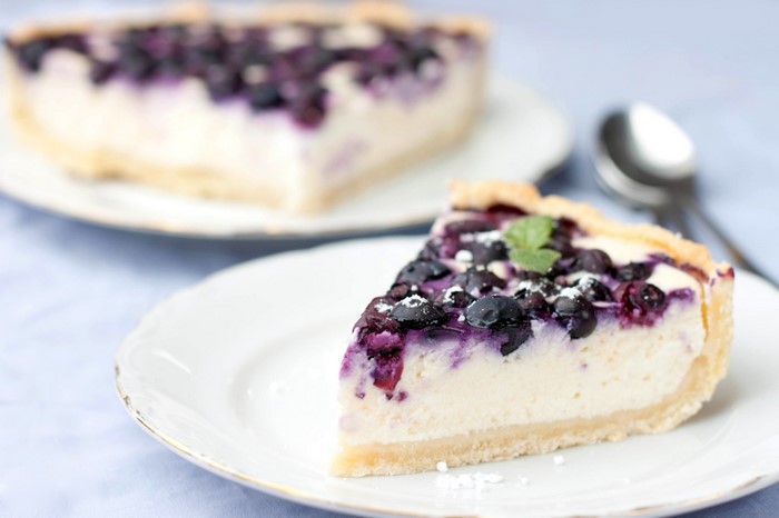 Slice of blueberry cheesecake with mint garnish