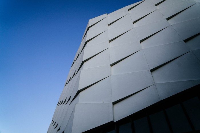 Modern building facade with geometric patterns against blue sky