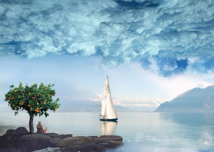 Surreal scene with orange tree, sailboat, and inverted clouds