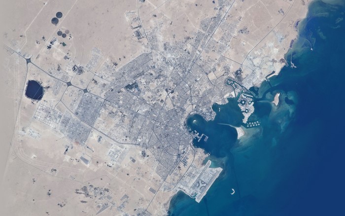 Aerial view of a coastal city with infrastructure and the sea