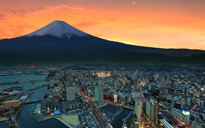 Mount Fuji over a city at sunset